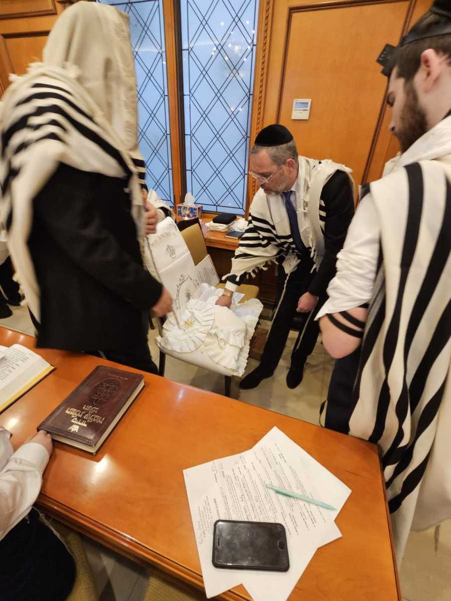 Rabbi Goldberg caring for the baby after the bris